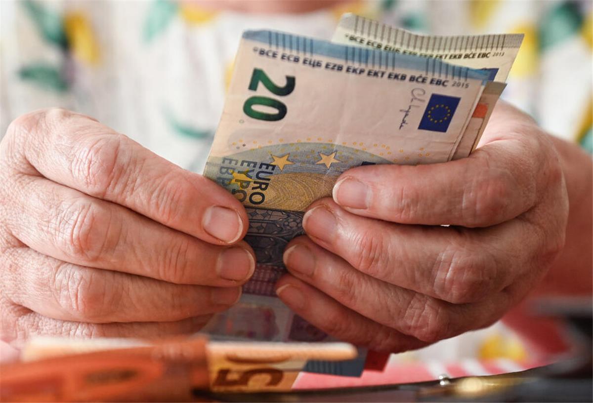 Besondere Ausnahme im August! Millionen Rentner erhalten ihr Geld früher Eine ältere Frau hält mehrere Geldscheine in der Hand. Rentner können sich freuen: Im August 2025 erhalten sie die Rente schon früher.