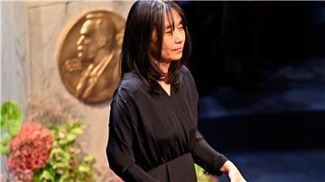 Han Kang mit ihrer Nobelmedaille und dem dazugehörigen Diplom.