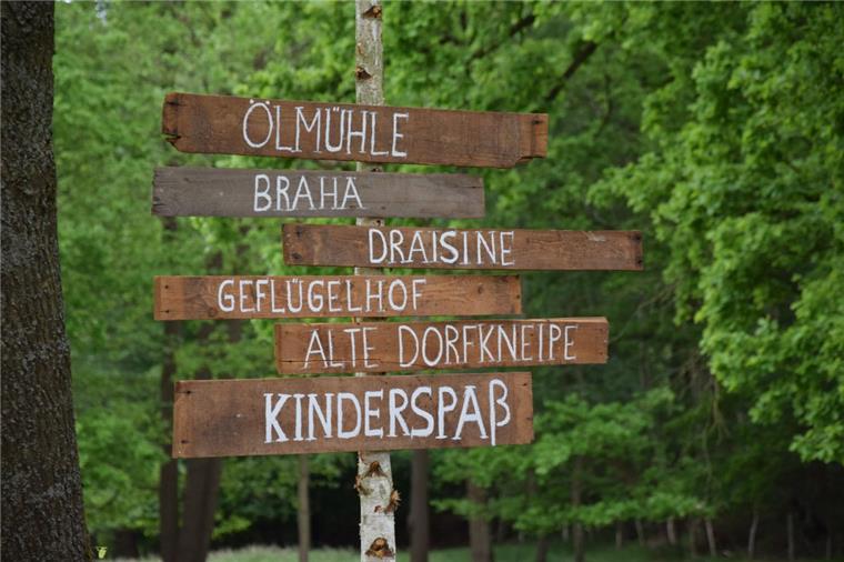Handgemachte hölzerne Schilder weisen in Godenstedt auf Attraktionen beim "Tag des offenen Dorfes" hin.