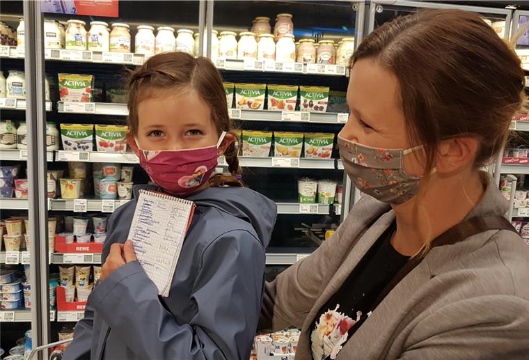 Hanna ist acht Jahre alt und streicht alles aus der Einkaufsliste ab, was ihre Mama Jana Kuntzmann einkauft.