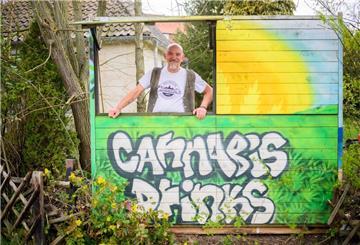 Heinrich Wieker vom Cannabis Socialclub Hannover e.V. an seinem Gartenzaun an einer Bretterbude.