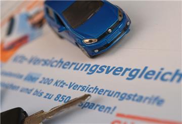 Ein Miniaturauto und ein Autoschlüssel liegen auf einem Ausdruck.