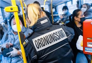 Eine Mitarbeiterin des Ordnungsamts Lübeck überprüft in einem Linienbus den Impfstatus oder Testnachweis eines Fahrgastes. 