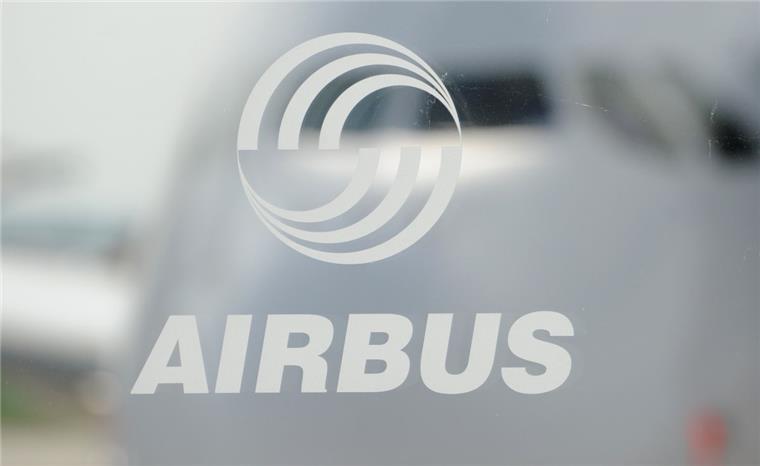Hinter dem Logo des Flugzeugherstellers Airbus ist das Cockpit eines A380 zu sehen. Schon vor längerem hatte Airbus angekündigt, weniger Maschinen etwa vom Großraumflieger A380 auszuliefern. Doch wie viele Mitarbeiter will der Konzern einsparen? Streichungen würden auch deutsche Standorte treffen. 