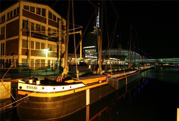 Bremerhaven versteigert Koggenbräu-Gebäude Ein Holzschiff liegt bei Nacht vor dem Koggenbräu-Gebäude in Bremerhaven.