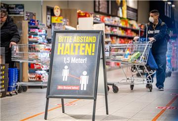 Hinweisschilder am Eingang und entlang der Kassen weisen die Kunden auf den nötigen Sicherheitsabstand hin. Supermärkte haben unterschiedliche Ansätze, das Einhalten der Abstände sicherzustellen.