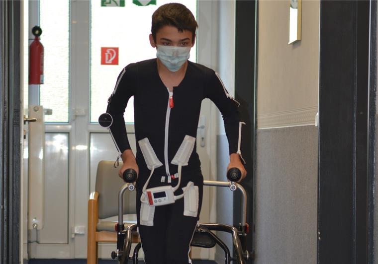 Elektrodenanzug aus Debstedt hilft Schlaganfallpatienten Ein Junge in einem Elektrodenanzug geht an einer Gehhilfe.