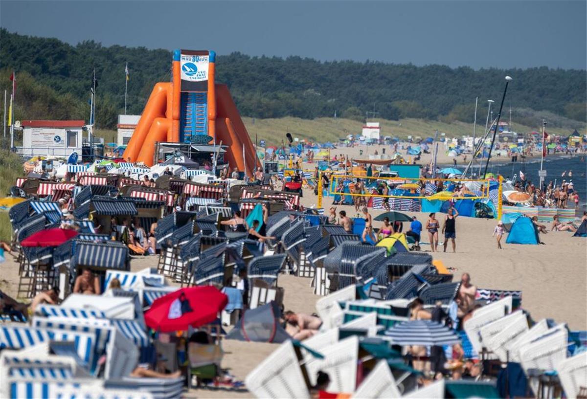 Urlaubsregion in Deutschland schlägt Alarm! Trinkwasser wird knapp Touristen sind bei sonnigem Wetter im Ostseebad Zinnowitz am Strand unterwegs.
