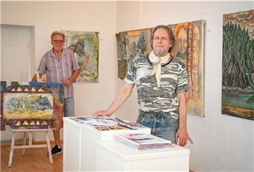 Holzrahmen mit Goldmuster? Der Schein trügt: Wilfried Klausings Bild, das Galerist Vladimiro Miszak links präsentiert, ist auf Cornflakes-Packungen gemalt. Foto Scheschonka