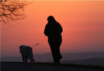 Spaziergänger mit Hund an der Leine.