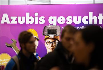 Besucher stehen auf der Jobmesse «KarriereStart» vor dem Schriftzug "Azubis gesucht"