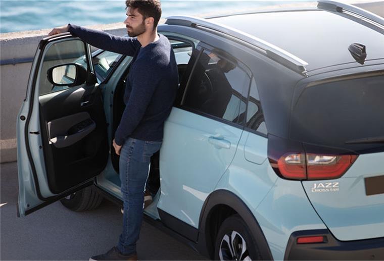 Hybridtechnik: Für eine grünere Zukunft Mann steht in der Tür seines Autos