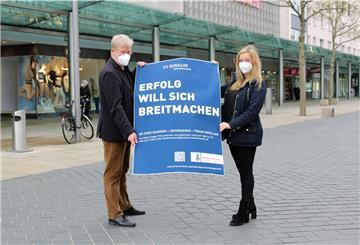Ideen fürs Ladenflächenmanagements in der Bremerhavener Innenstadt: Dr. Ralf Meyer und Laura Kottsieper präsentieren ein Plakat zur aktuellen Aktion.