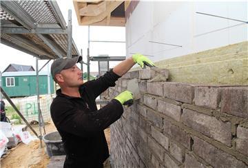Igor Alcedarevschi versteht sein Handwerk: Der Maurer lässt die Klinkersteine zu einer Fassade in die Höhe wachsen - aufmauern nennt man das.
