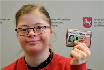 Ihren selbstentworfenen "Schwer-in-Ordnung-Ausweis" hält die 14-jährige Hannah Kiesbye in die Kamera.