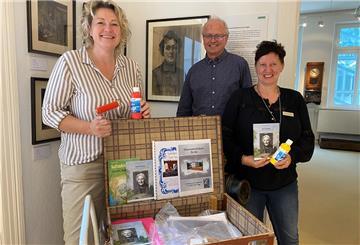 Ilona Tetzlaff, Geschäftsführerin von NMT: Nordenham Marketing&Touristik (links), Museumsleiter Dr. Timothy Saunders und Svenja Faehse (NMT) präsentieren den neuen "Emy-Rogge-Lernkoffer" im Nordenhamer Museum.