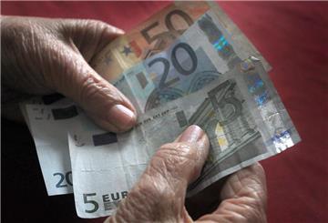 Eine ältere Frau hält verschiedene Euronoten in der Hand.
