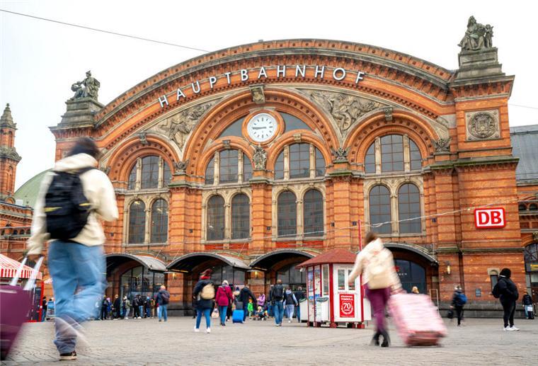Reisende mit Koffern laufen zum Bremer Hauptbahnhof.