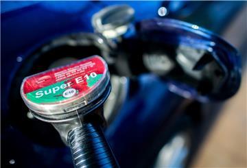 Eine Zapfpistole mit der Aufschrift «Super E10» steckt an einer Tankstelle in der Tanköffnung eines Fahrzeugs.