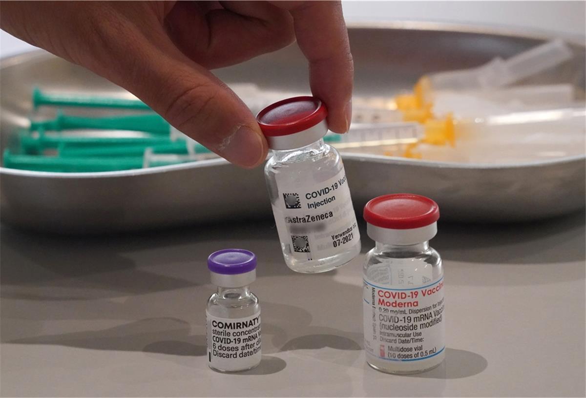 Ein Mitarbeiter des Impfzentrums in den Messehallen nimmt eine Impfdose vom Impfstoff Astrazeneca vom Tisch. 