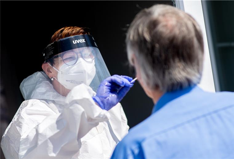 Eine Mitarbeiterin eines Testcenters am Fähranleger nimmt einen Abstrich von einem Touristen