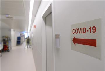 Ein Richtungspfeil zum "Covid-19" Bereich klebt vor einer Corona-Intensivstation an der Wand.