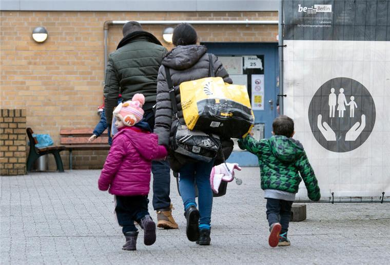 Diese Sozialleistungen erhalten Migranten in Deutschland und in anderen Ländern Ein Flüchtling geht mit seiner Familie auf dem Gelände der Erstaufnahmeeinrichtung des Landesamtes für Flüchtlingsangelegenheiten (LAF) in Reinickendorf.