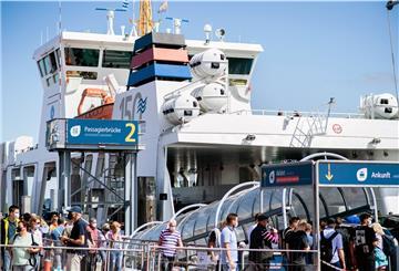 Touristen betreten im Fährhafen ein Fährschiff der Reederei Norden-Frisia, um auf die Insel Norderney zu fahren.