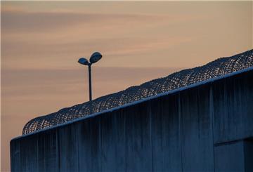 Der Tag bricht über der drahtbewährten Mauer der Justizvollzugsanstalt Burg an.