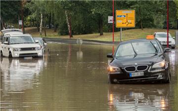 Im hessischen Stadtallendorf stehen Autos nach einem kurzen und starken Regenguss auf einer überfluteten Strasse. Die Regenmassen hatten ganze Straßenzüge geflutet, Gebäude standen im Keller ebenfalls unter Wasser. 