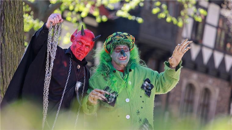 Im Hexen- und Teufelskostüm stehen zwei Walpurgisbesucher in Wernigerode vor der Erstürmung des Rathauses im Stadtzentrum.