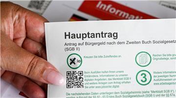 Im Jobcenter hält eine Frau einen Antrag auf Bürgergeld in der Hand.