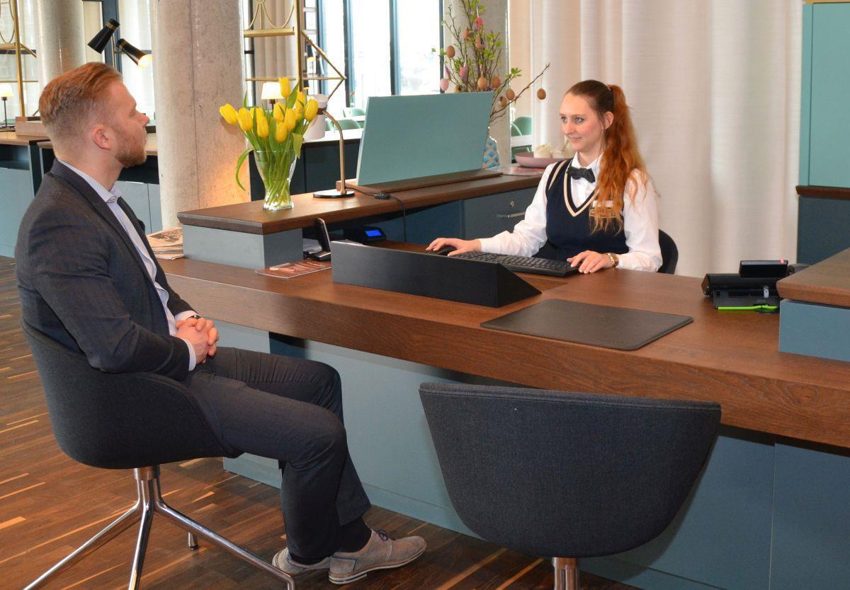 Im Rezeptionsbereich des Liberty-Hotels besteht die Möglichkeit, sich beim Einchecken hinzusetzen oder direkt im Rollstuhl auf Augenhöhe mit der Empfangsleitung Alina Wolff ins Gespräch zu kommen.  