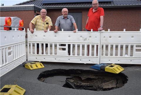 Anwohner vor einem Loch im Taubenweg