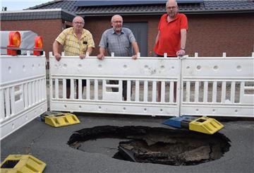 Anwohner vor einem Loch im Taubenweg