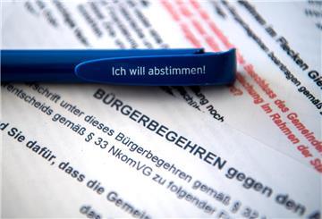  Ein Stift mit der Aufschrift «Ich will abstimmen!» liegt auf Zetteln mit Bürgerbegehren auf dem Schreibtisch 