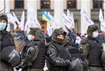 Bereitschaftspolizisten beobachten Demonstranten, die vor Regierungsgebäude protestieren. 