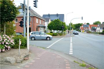 Im Zuge der Gehweg-Erneuerung wird der Bürgersteig im Bereich der Einmündung der Ziegeleistraße im rückwärtigen Bereich verbreitert. Dazu müssen ein Busch (links im Bild) sowie zwei Kugelahorne (Mitte) entfernt werden.