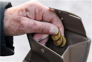  Eine Frau am holt Münzen aus ihrem Portemonnaie. 