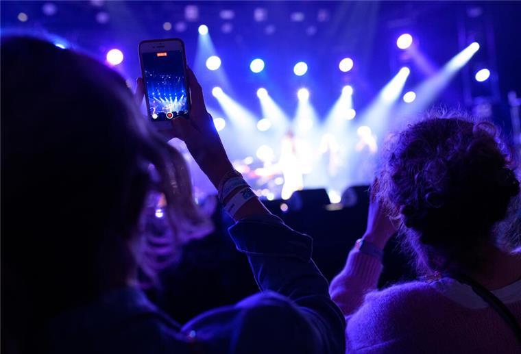 Keine Smartphones erlaubt: Warum Künstler immer öfter das Handy verbannen Eine Zuschauerin filmt vor der Bühne mit ihrem Handy.