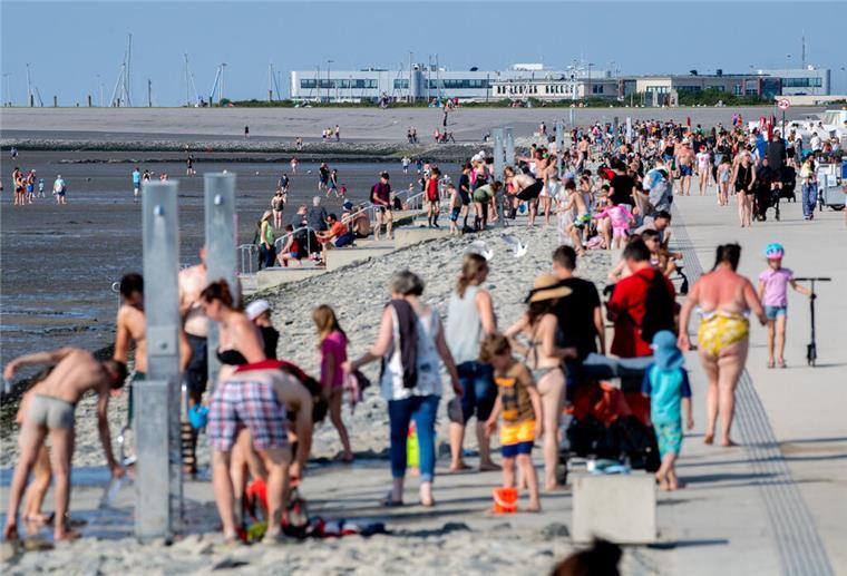 Zahlreiche Strandkörbe und Strandzelte stehen bei sonnigem Wetter am Strand