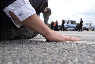 Ein Klimaaktivist hat sich mit der Handfläche am Asphalt einer Straße in der Bremer Innenstadt festgeklebt