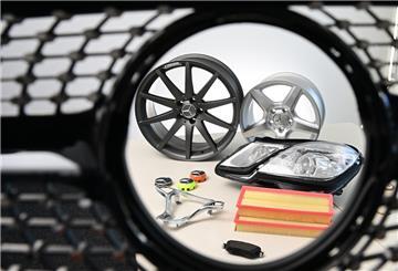 Gefälschte Mercedes-Benz Autoteile liegen in einem Büro des Fahrzeugherstellers Mercedes-Benz auf einem Tisch, fotografiert durch einen gefälschten Kühlergrill.
