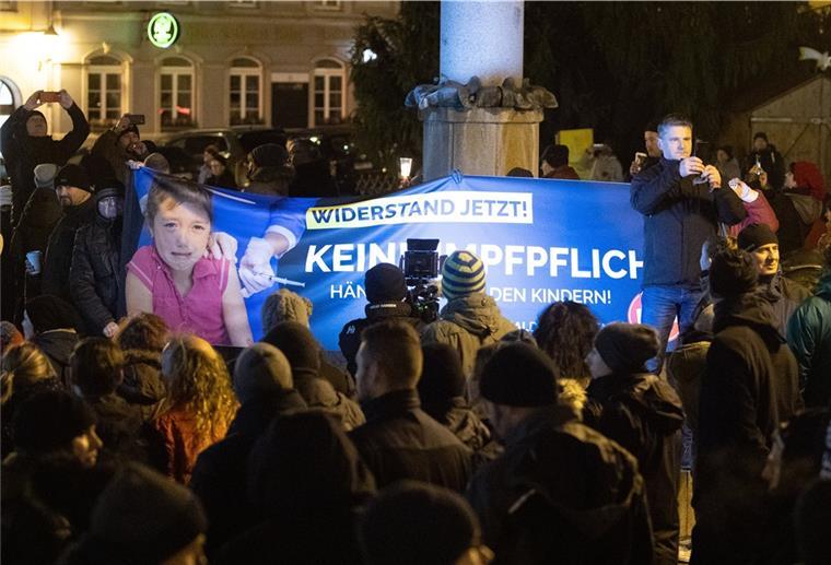 Impfgegner und Kritiker der Corona-Maßnahmen gehen während eines Protest gegen Corona-Maßnahmen und eine mögliche Impfpflicht in Deutschland über den Hauptmarkt in Bautzen.