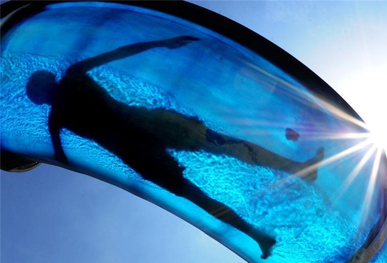 Frau bleibt 80 Minuten in Schwimmbadrutsche stecken Ein Junge rutscht am Dienstag (22.05.2012) im Gegenlicht der Mittagssonne über eine Wasserrutsche im Südbad in Hameln.
