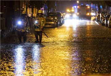 Feuerwehrleute suchen auf einer überfluteten Straße in Duisburg nach Gullydeckeln. Mit teils heftigen Regenfällen und Gewittern hat ein Unwetter Nordrhein-Westfalen am Donnerstag erreicht. +++ dpa-Bildfunk +++