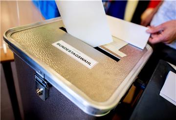Ein Wähler wirft in einem Wahllokal seinen Stimmzettel für die Bundestagswahl in eine Wahlurne.