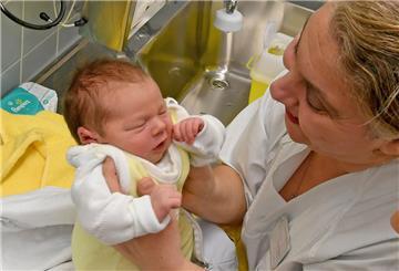 Ein Baby wird von einer Hebamme betreut.