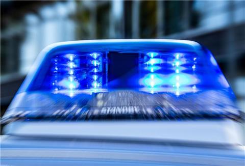 Ein Blaulicht leuchtet auf dem Dach eines Polizeiwagens. 