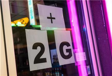 Schilder, die auf "2G-plus" hinweisen, hängen an einem Tanzlokal